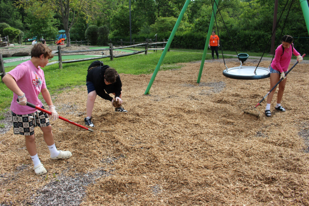 Students spread mulch at Grand Vue's playground.