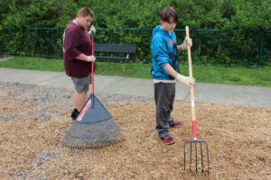 Students spread mulch at Grand Vue's playground.