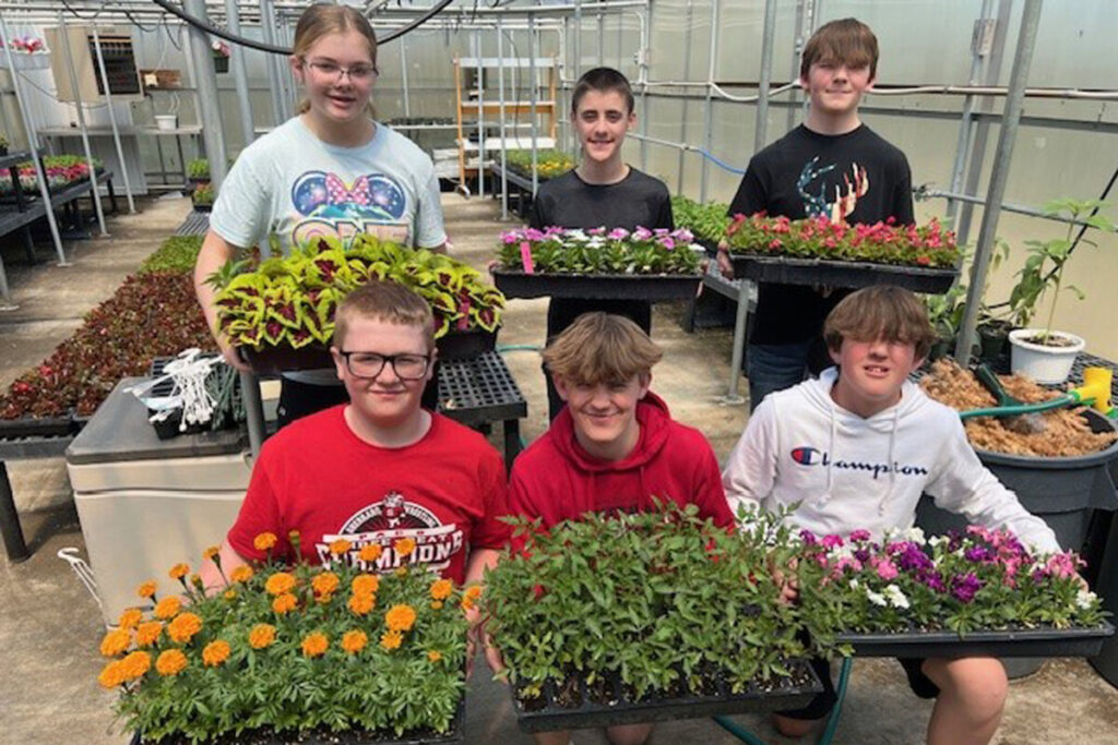 SMS students in the Greenhouse class are pictured with a sample of the flowers for sale. Front row from left: Jacob Logsdon, Ruxin Allman and Chance Richards. Back row from left: Addison Mlodzik, Aydin MacFarland and Dalton Kale.